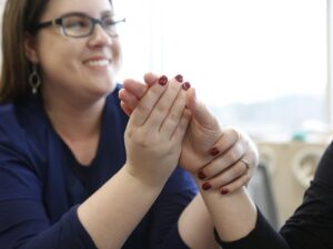 An occupational therapy works with a patient's hand