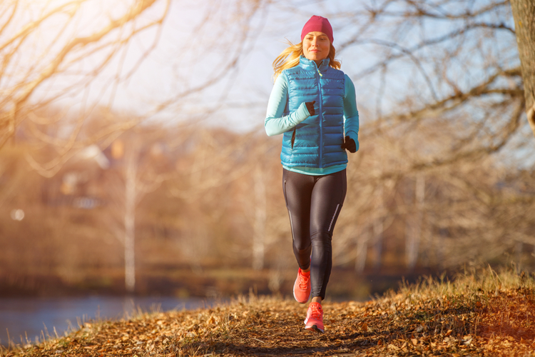 Woman runs along park path in cold weather