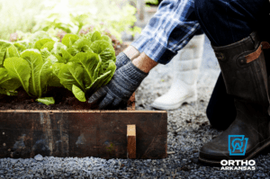 Closeup of gardener working outside in raised garden bed