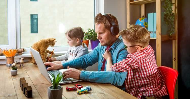 Work from home parent looking stressed during video meeting while kids play in background