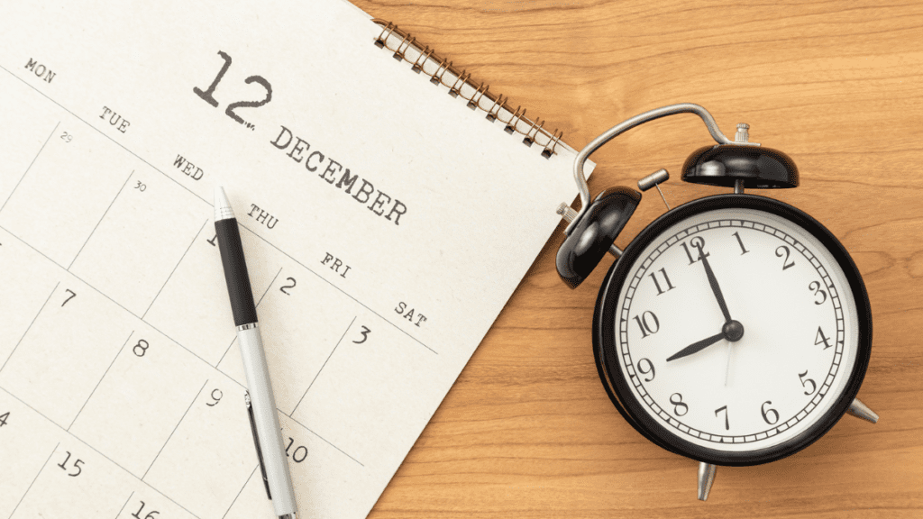 calendar with the month of december on it, next to it there is a clock